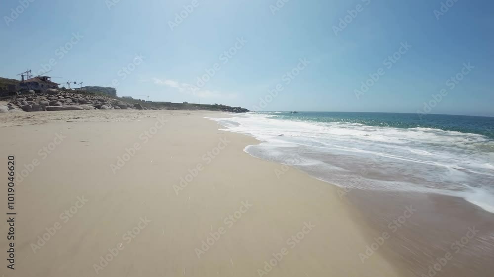 A model girl in a hat and a black dress walks along the shore of the Atlantic Ocean.Portugal A model girl in a hat and a black dress walks along the shore of the Atlantic Ocean.Portugal