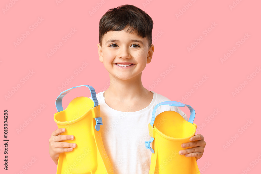 Cute little boy with yellow flippers on pink background Cute little boy with yellow flippers on pink background