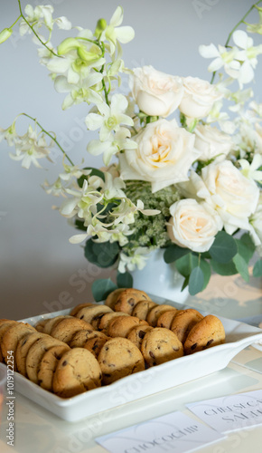 Galletas de boda junto a flores blancas.