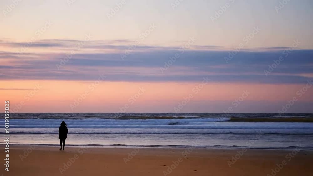 person walking on the beach at sunset person walking on the beach at sunset