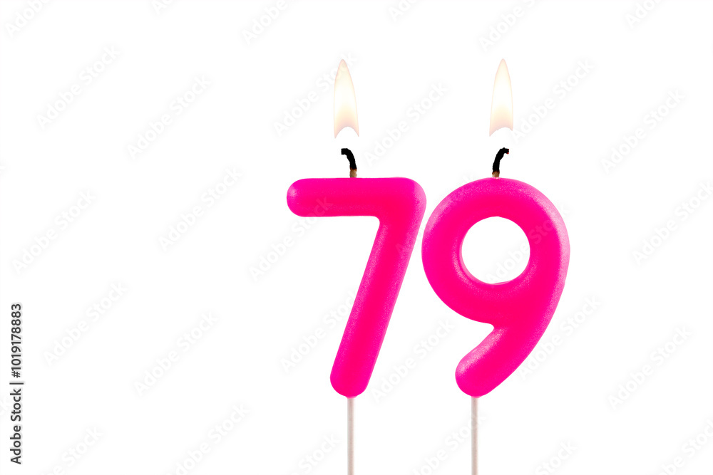 Pink number 79 birthday candle lit on white background Pink number 79 birthday candle lit on white background