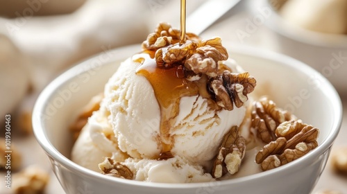 Obraz na płótnie A scoop of vanilla ice cream topped with chopped walnuts and a drizzle of caramel sauce in a white bowl. w salonie