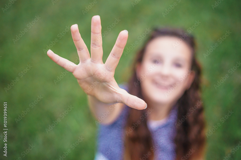 Unfocused high angle view of a beautiful little girl smiling happily, reaching her hand towards the camera as if she is going to take it. Unfocused high angle view of a beautiful little girl smiling happily, reaching her hand towards the camera as if she is going to take it.