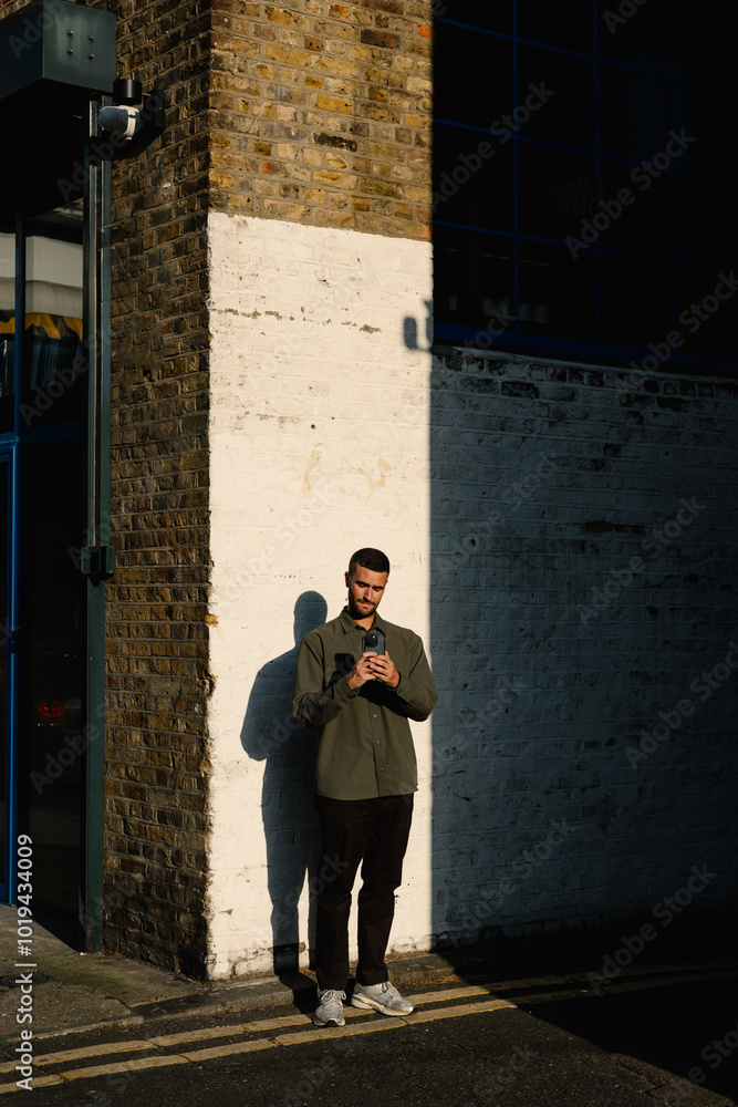 A tourist uses his smartphone to photograph the streets of Dalston A tourist uses his smartphone to photograph the streets of Dalston