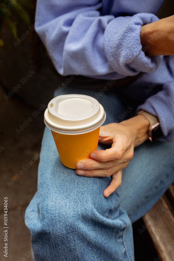 The hands of an unidentified woman holding a disposable coffee cup The hands of an unidentified woman holding a disposable coffee cup