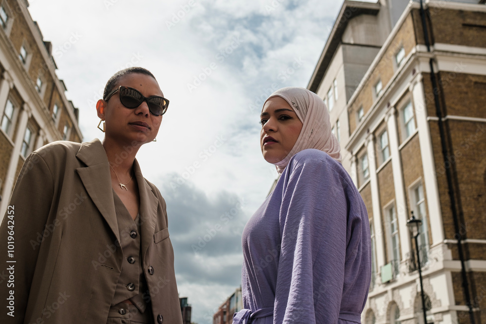 Serious couple of female friends posing in a London street. Serious couple of female friends posing in a London street.