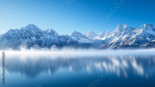Wallpaper Mural A serene mountain range where snow-covered peaks form a natural ring around a frozen lake, with mist rising from the cold surface, under a clear blue sky Torontodigital.ca