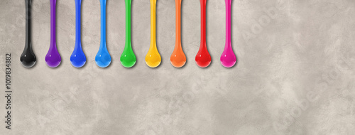 Colorful ink drops on light concrete wall. Horizontal banner