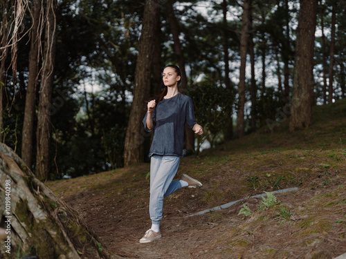 Energetic young woman jogging in the forest path, wearing casual sportswear Embracing health and outdoor activities in a natural environment