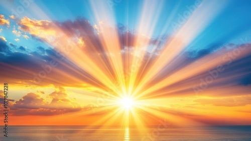 A vibrant sunrise with golden rays illuminating the ocean and sky.