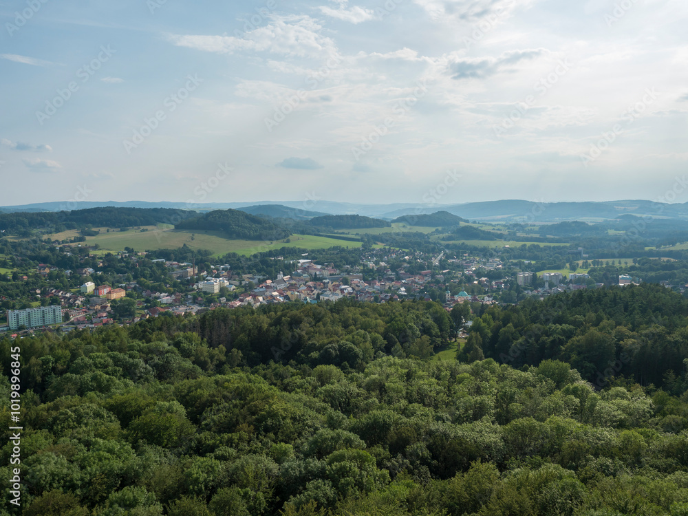 Obraz premium Panoramic view from sandstone rock lookout Jehla near Ceska Kamenice town. Summer landscape in Lusatian Mountains with green hills and mixed forest.