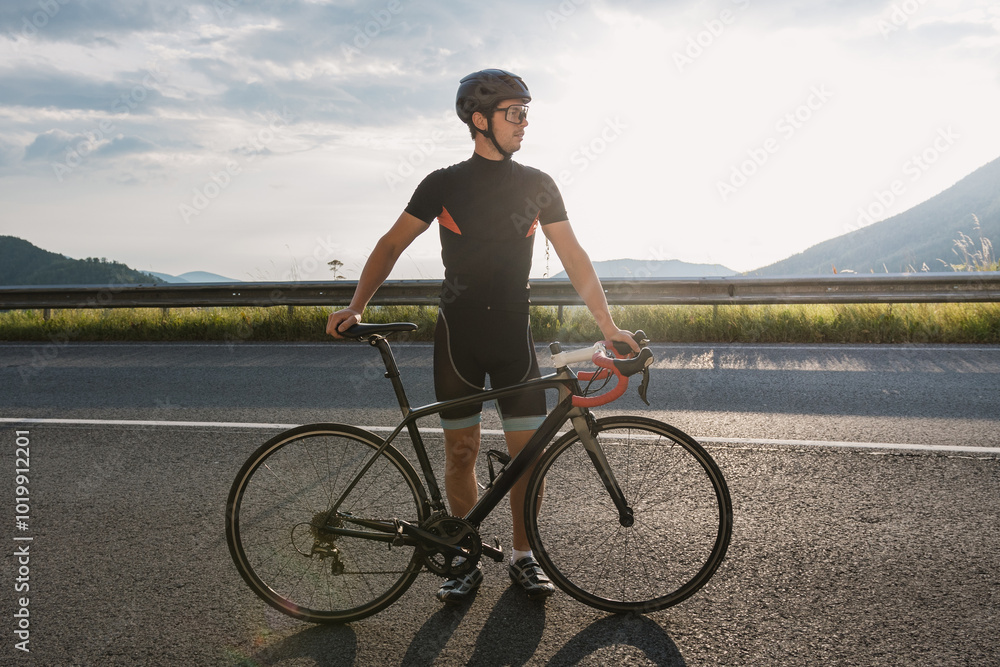 Man on road bike in morning sun in Austrian alps. Man on road bike in morning sun in Austrian alps.