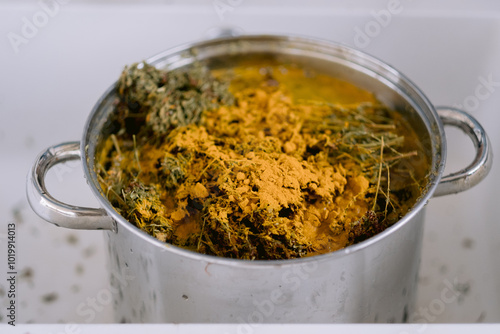 Large pot with yellowish herbal mixture soaking inside.