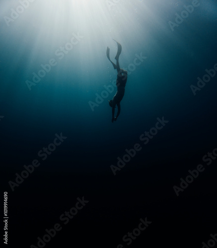 Man dives towards the bottom of the ocean photo