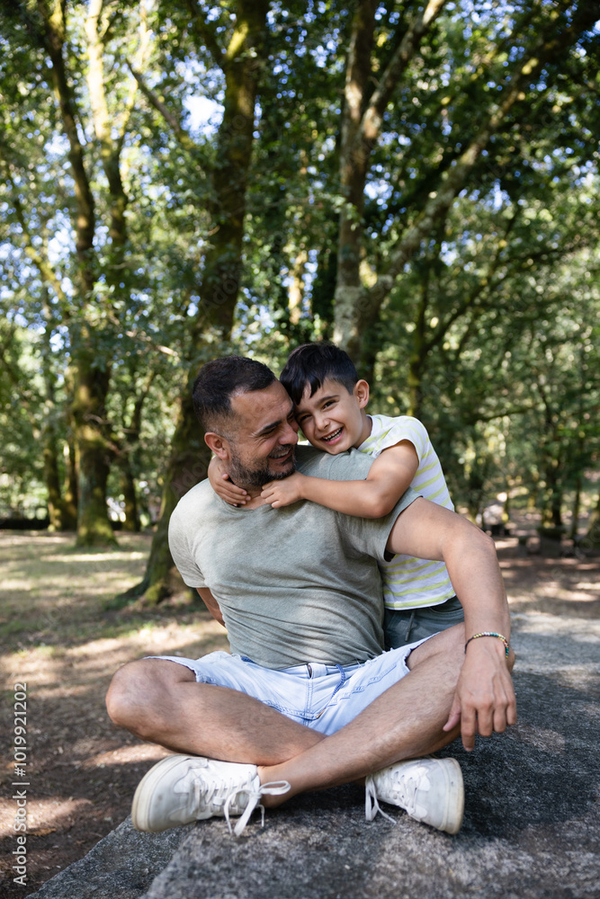 Father and son enjoying a playful moment in a forest setting Father and son enjoying a playful moment in a forest setting