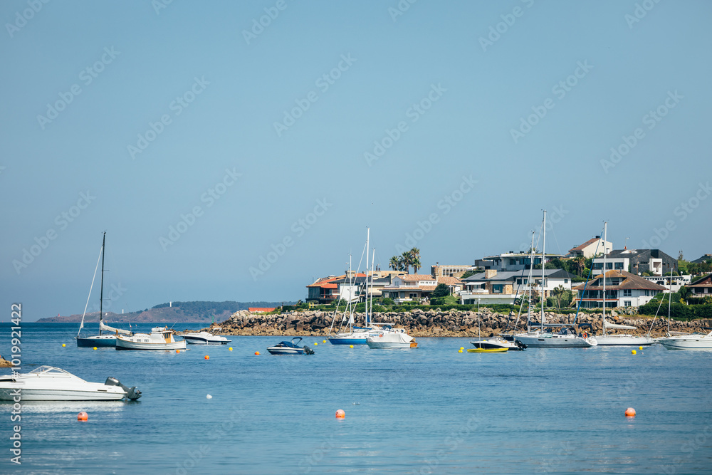 Isla de Toralla with boats anchored near the shore on a sunny day Isla de Toralla with boats anchored near the shore on a sunny day