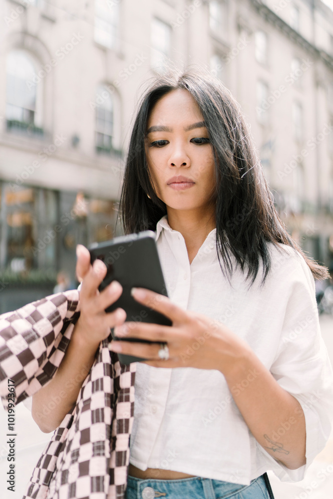 Woman Checking Phone in City