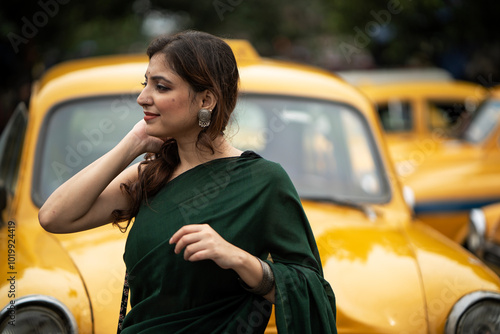 Good looking Indian woman standing in a street with background of taxi photo