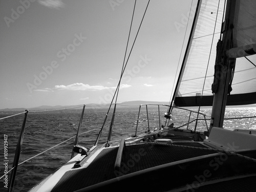 Black and white photo of vintage sailboat coming into harbour photo