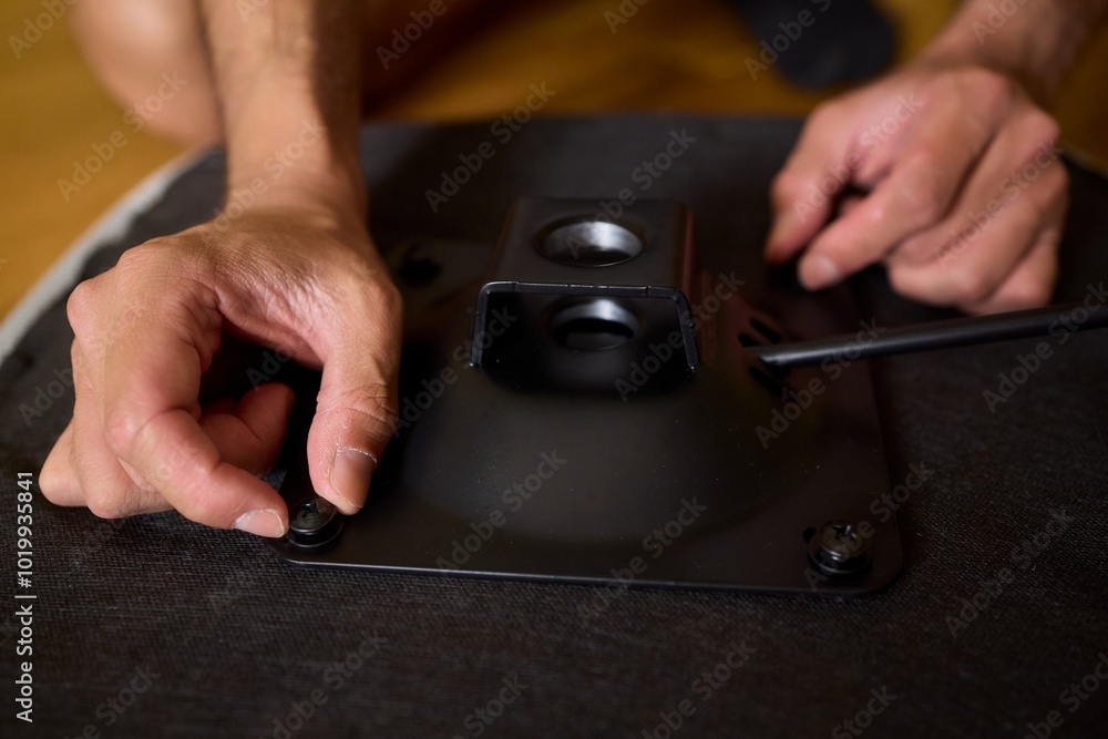 A Young Man Assembling a Stylish Modern Chair in a Comfortable Minimalist Interior Space A Young Man Assembling a Stylish Modern Chair in a Comfortable Minimalist Interior Space