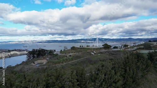 A smooth drone push-in reveal shot of The Bay Bridge from Yerba Buena Island, CA, showcasing the bridge and scenic bay. Ideal for urban, transportation, and travel footage. photo