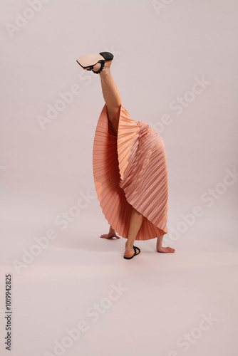 Contemporary Dancer in Unique Pose with Pleated Peach Dress photo