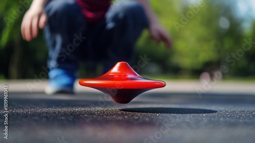 a child playing with a top, watching it perform a mesmerizing backspin on a smooth surface photo