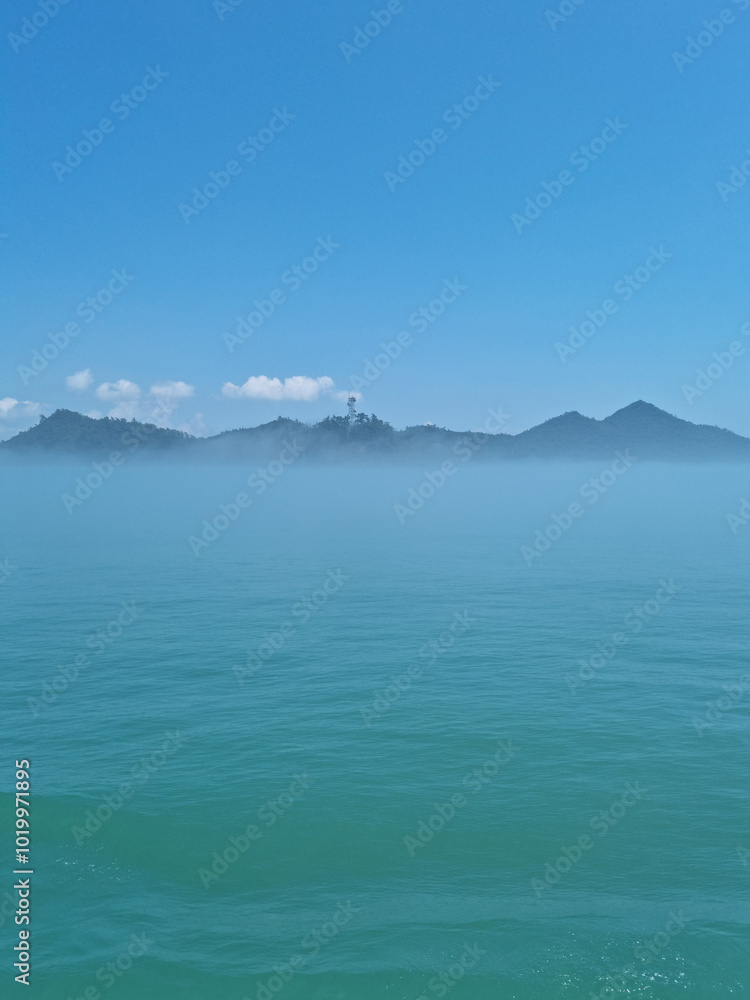 It is a foggy sea and island. It is a foggy sea and island.