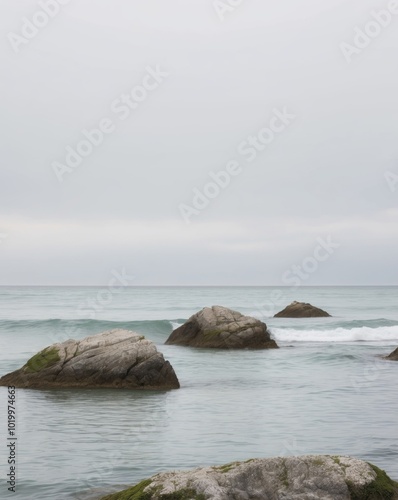 Calm Ocean Scene with Rocks Under Overcast Sky.