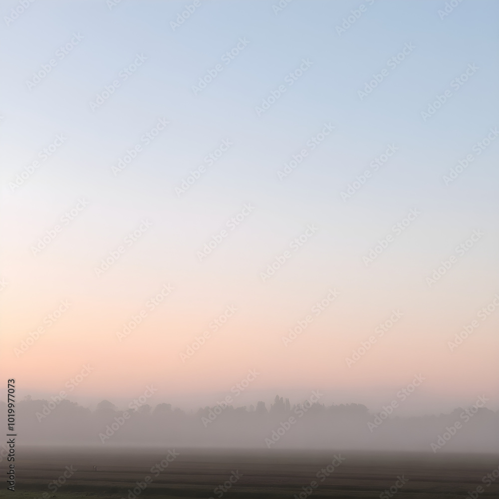 Fototapeta premium A soft, misty morning sky with pastel tones of pink and blue, with the fog rising from the fields and trees barely visible in the distance 