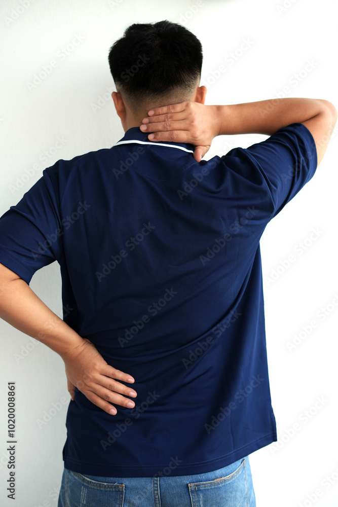 Tired young asian business man suffering neck and hand pain while working for so long at home, exhausted man rubbing and massaging his painful area and frowning, suffering osteoporosis or arthritis Tired young asian business man suffering neck and hand pain while working for so long at home, exhausted man rubbing and massaging his painful area and frowning, suffering osteoporosis or arthritis