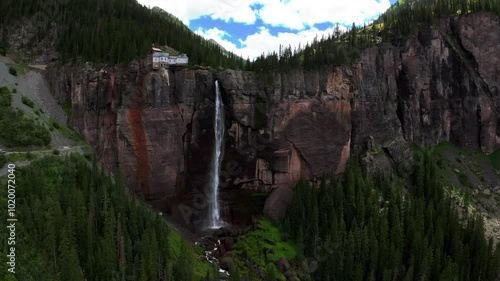 Telluride Bridal Veil Falls Waterfall Colorado powerplant house aerial drone forward pan shade Aspen Trees Uncompahgre Forest summer green Box Canyon Black Bear Pass Road Rocky Mountains 4wd blue sky photo