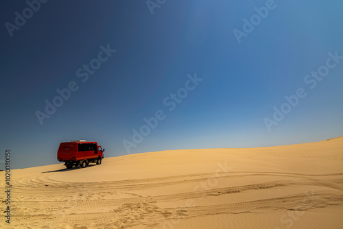 Desert sanddunes with foot tracks and blue sky