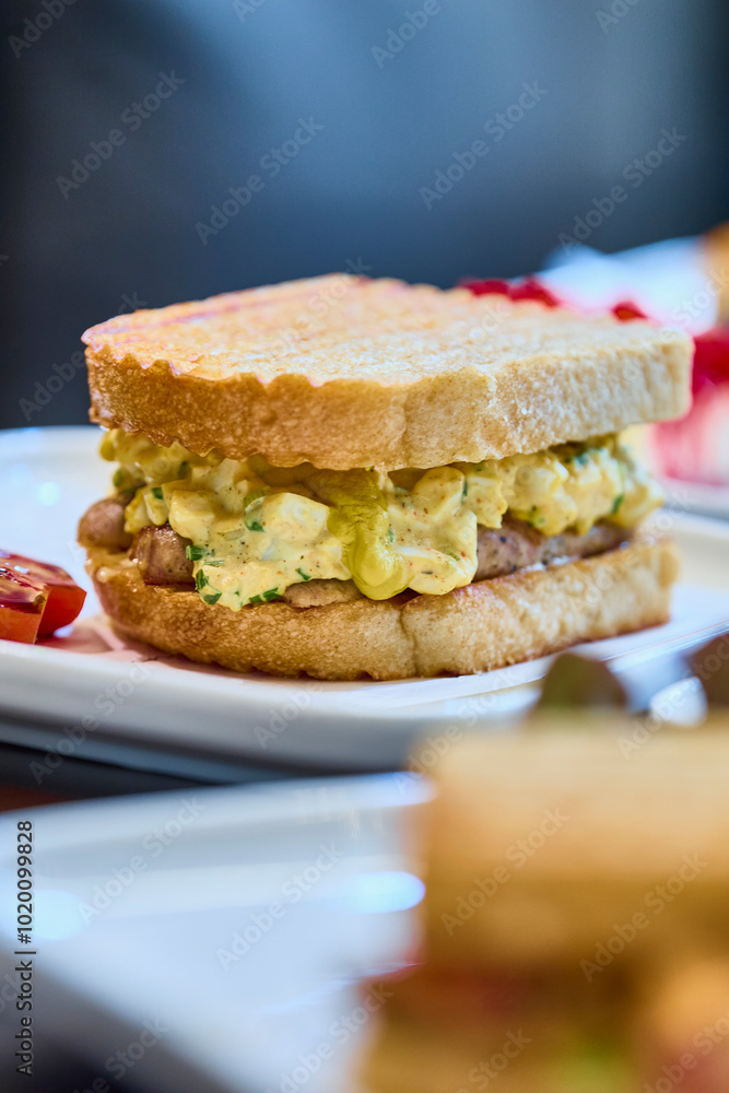 close up of a sourdough sandwich with egg salad and sausages close up of a sourdough sandwich with egg salad and sausages