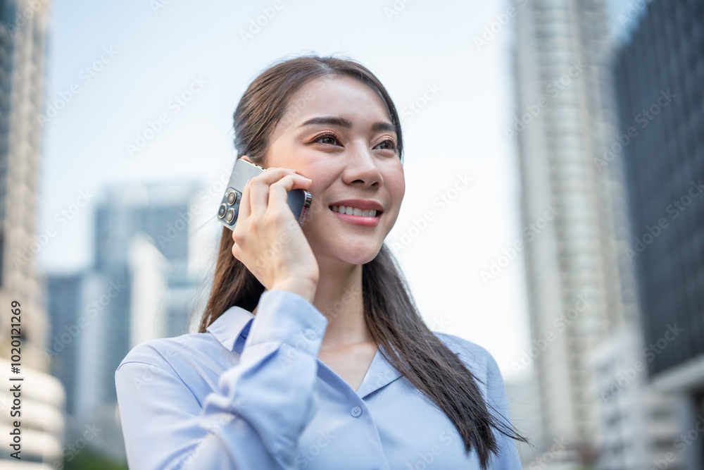 Asian young businesswoman talking on smartphone while walk in the city. Asian young businesswoman talking on smartphone while walk in the city.