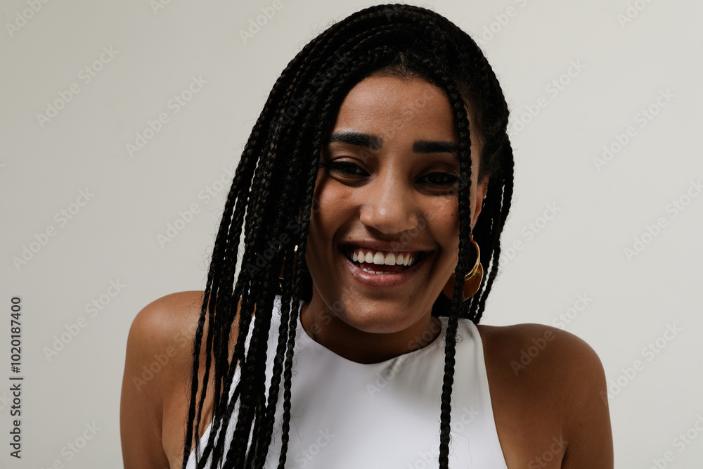 Happy African American young woman with long dark braids looking at the camera. Happy African American young woman with long dark braids looking at the camera.