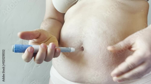 Woman making Semaglutide Injection closeup. Semaglutide or insulin Injection pen in female belly. Semaglutide Diabetes Drug Being Used For Weight Loss. photo