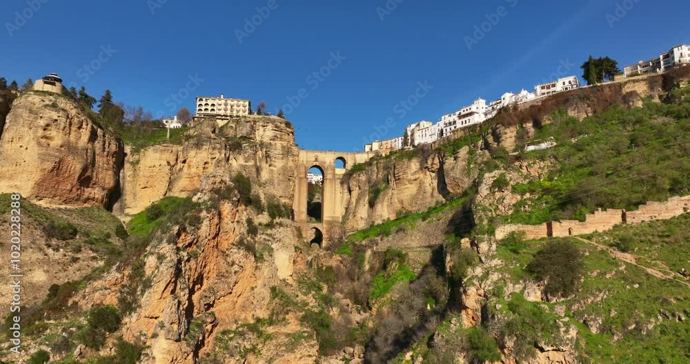 Ascending forward flying aerial shot of Ronda City in Spain, Europe. Arch bridge, homes, streets are located on the cliff. Mountains are visible in the background. High quality 4k prores footage. Ascending forward flying aerial shot of Ronda City in Spain, Europe. Arch bridge, homes, streets are located on the cliff. Mountains are visible in the background. High quality 4k prores footage.