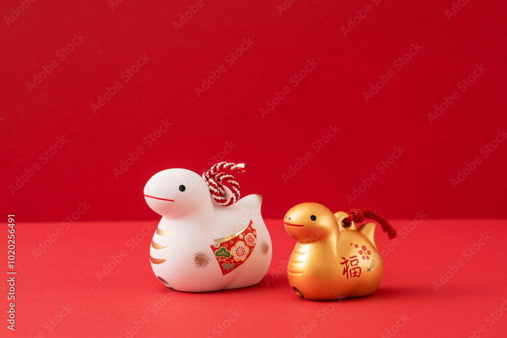 Japanese new year material. Zodiac Snake. Snakes ornament on the red background. 日本のお正月素材。干支の巳(ヘビ)。赤背景上の巳の置物 Japanese new year material. Zodiac Snake. Snakes ornament on the red background. 日本のお正月素材。干支の巳(ヘビ)。赤背景上の巳の置物