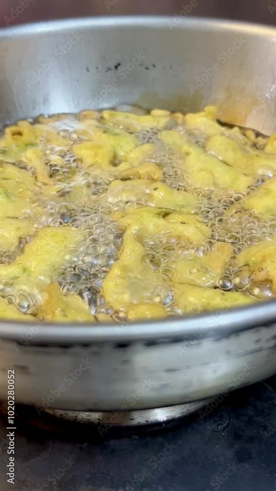 Frying chilli pakore or pakora in a frying pan or wok. Frying chilli pakore or pakora in a frying pan or wok.