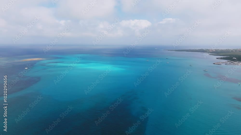 Aerial view of Sardinia's coastline in Italy, showcasing turquoise waters, boats, and small islands under clear skies with scattered clouds. Aerial view of Sardinia's coastline in Italy, showcasing turquoise waters, boats, and small islands under clear skies with scattered clouds.