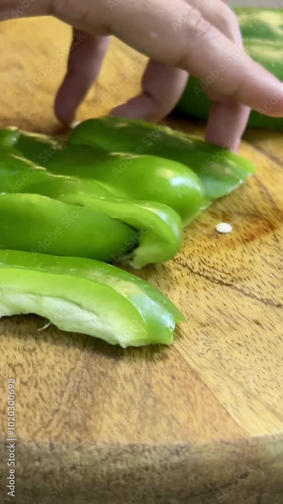Capsicum cutting into slices on a chopping board. capsicum slices. Capsicum cutting into slices on a chopping board. capsicum slices.