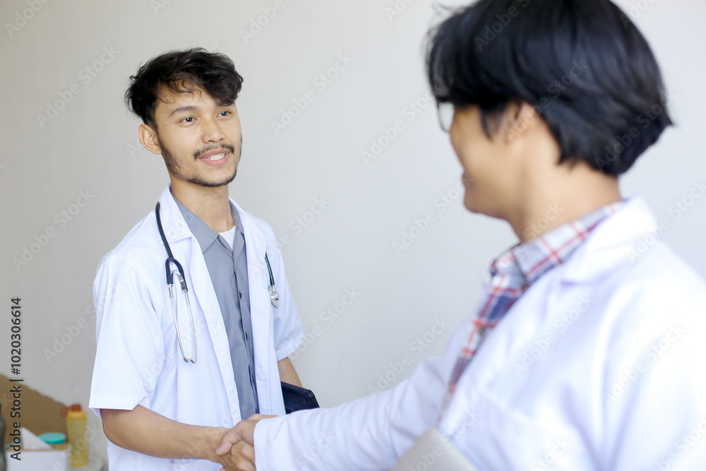 Two Asian Medical Students Shaking Hands At Hospital Two Asian Medical Students Shaking Hands At Hospital