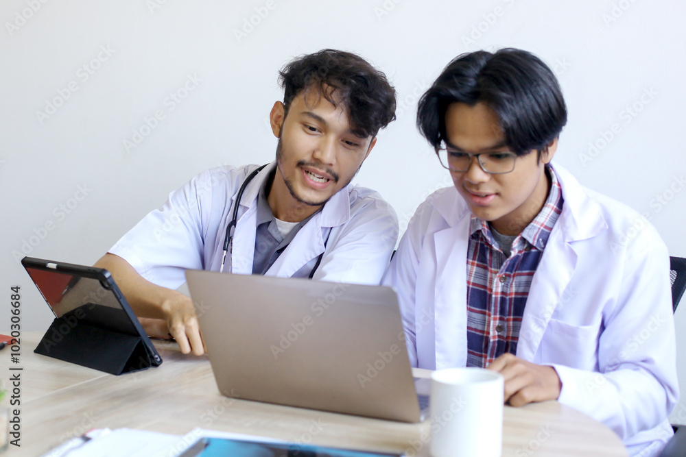 Two Young Asian Doctors Discussing Work At Hospital Two Young Asian Doctors Discussing Work At Hospital