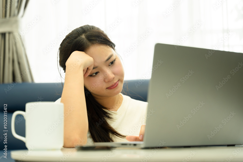 Portrait of young Asian girl using laptop and drink coffee , at home Portrait of young Asian girl using laptop and drink coffee , at home