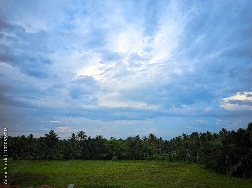 The photo depicts a beautiful landscape with a dramatic sky. The sky is divided into two distinct parts: one side is filled with dark, stormy clouds, while the other side is a clear, bright blue. The photo depicts a beautiful landscape with a dramatic sky. The sky is divided into two distinct parts: one side is filled with dark, stormy clouds, while the other side is a clear, bright blue.