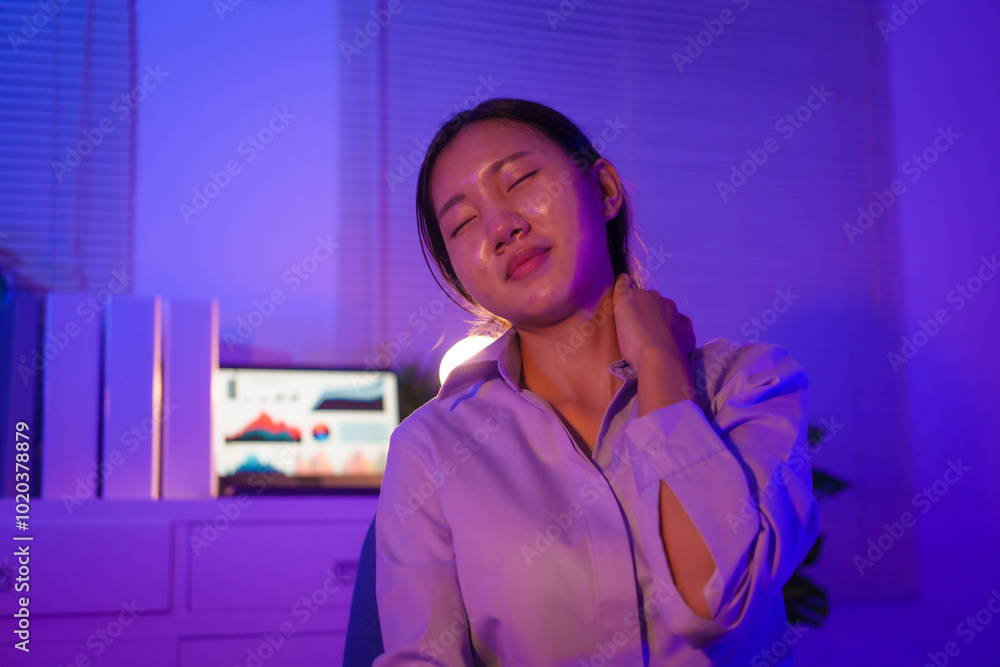 young Asian business trainee works late at desk, battling overtime and office syndrome. She struggles with neck, shoulder, back pain, along with eye strain, headaches, poor posture, mental fatigue young Asian business trainee works late at desk, battling overtime and office syndrome. She struggles with neck, shoulder, back pain, along with eye strain, headaches, poor posture, mental fatigue