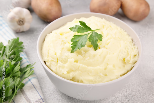 Mashed potatoes in white bowl on grey concrete background. Healthy food