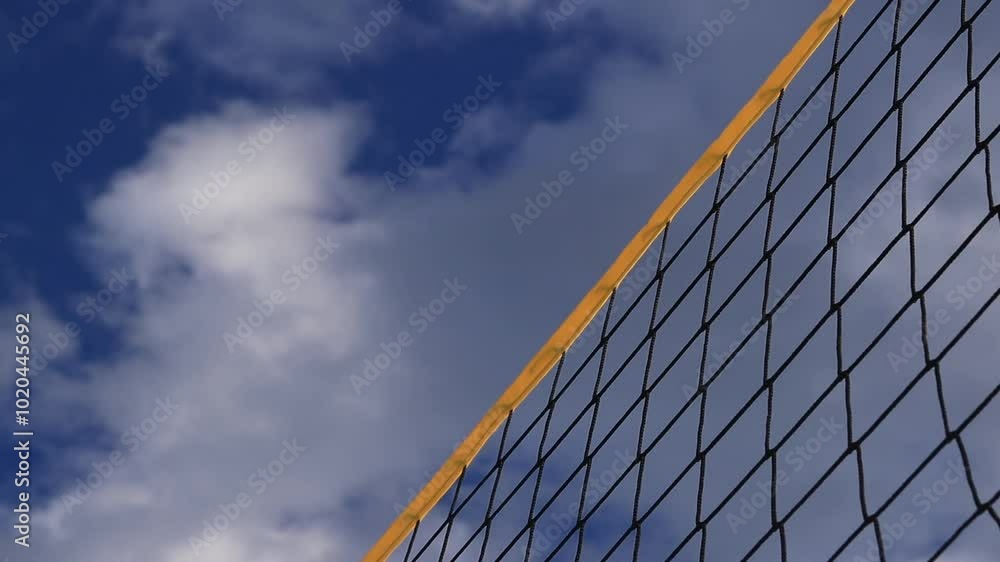 Beach volleyball net close-up. Fragment of a volleyball net on the beach against the blue sky. Sport, beach volleyball. Active recreation concept. Background. Detail of the yellow net. Sports ground Beach volleyball net close-up. Fragment of a volleyball net on the beach against the blue sky. Sport, beach volleyball. Active recreation concept. Background. Detail of the yellow net. Sports ground