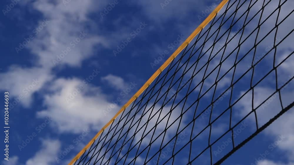 Beach volleyball net close-up. Fragment of a volleyball net on the beach against the blue sky. Sport, beach volleyball. Active recreation concept. Background. Detail of the yellow net. Sports ground Beach volleyball net close-up. Fragment of a volleyball net on the beach against the blue sky. Sport, beach volleyball. Active recreation concept. Background. Detail of the yellow net. Sports ground